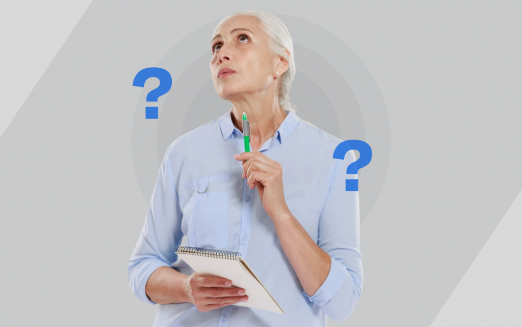 Uma senhora de cabelos brancos com uma caneta em uma das mãos e um bloco de notas na outra. Ela olha para cima pensativa e tem dois pontos de interrogação compondo a imagem, um à esquerda dela e outro à direita.